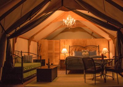 Cottage with beds and chandalier at night